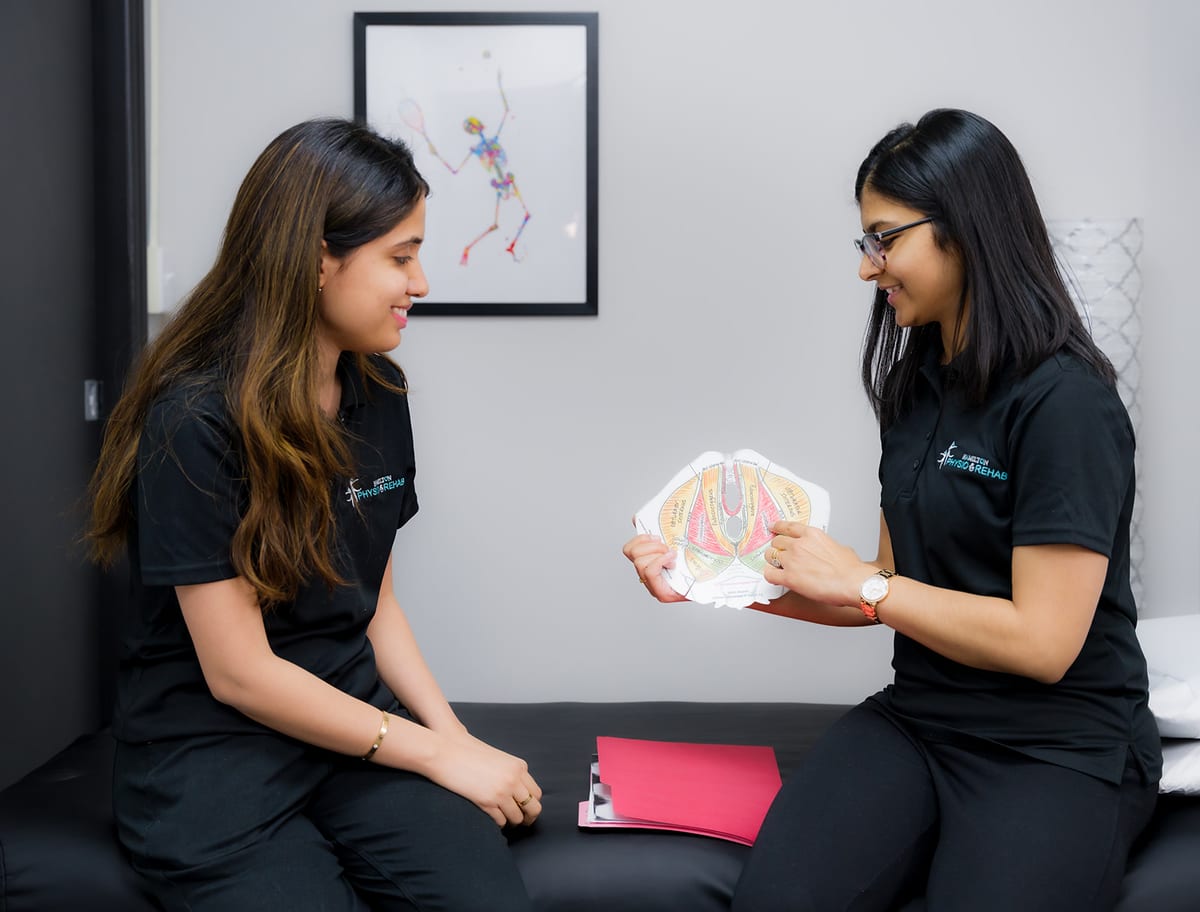 Two of the clinic's physiotherapists going through a pelvic floor anatomy model
